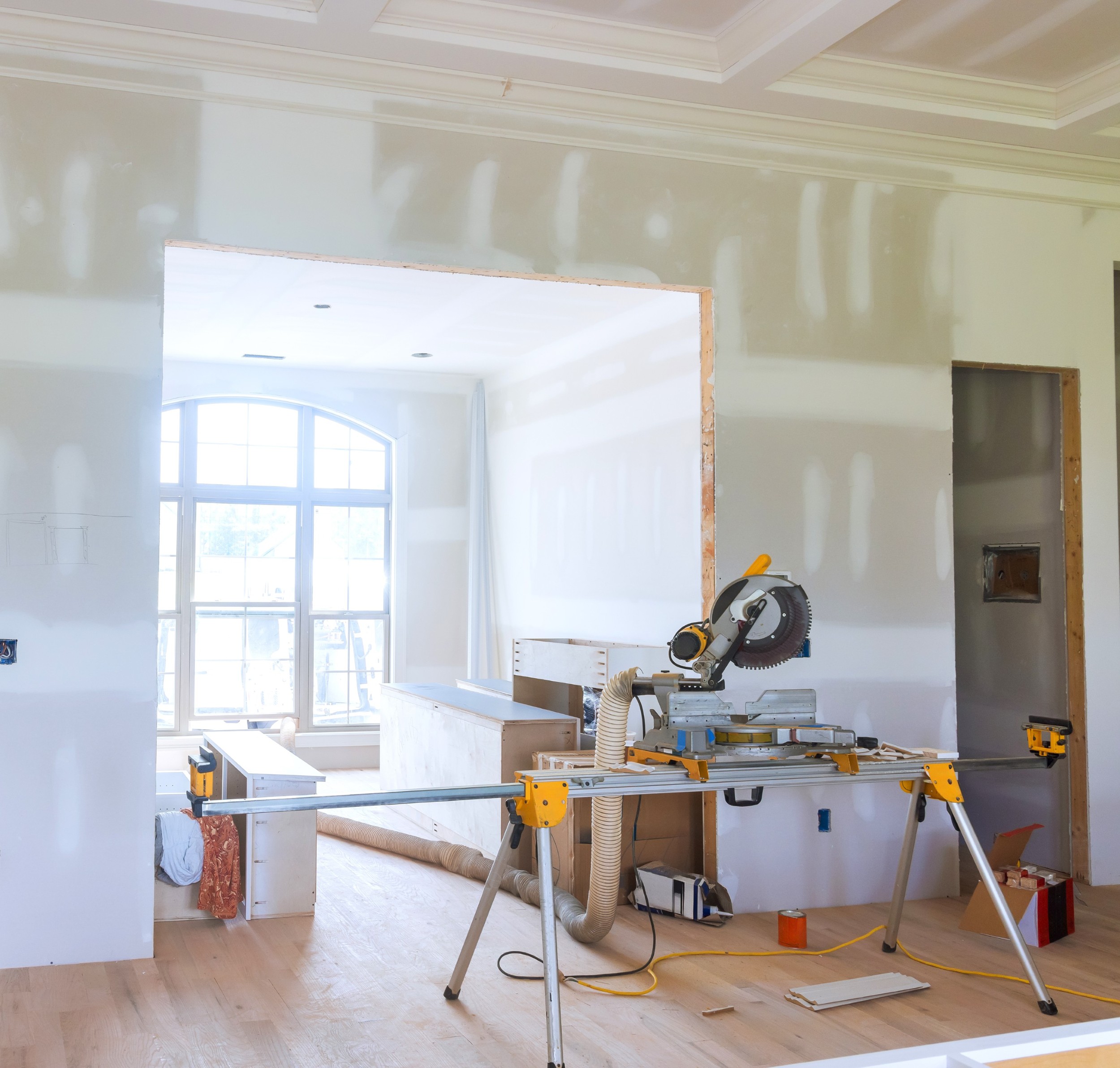 Construction progress showing partially finished interior with tools new doorway in home renovation project